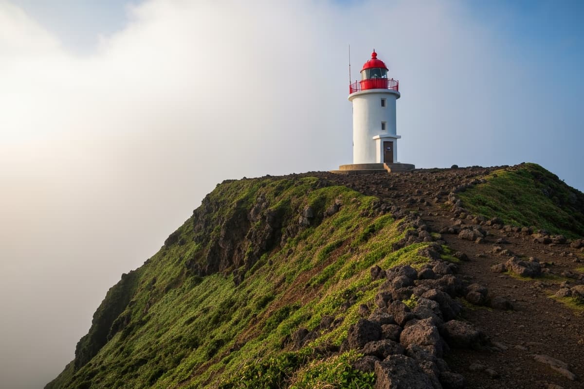 Biyang-bong's white lighthouse at the summit, with Hyeopjae's white sand visible across the water