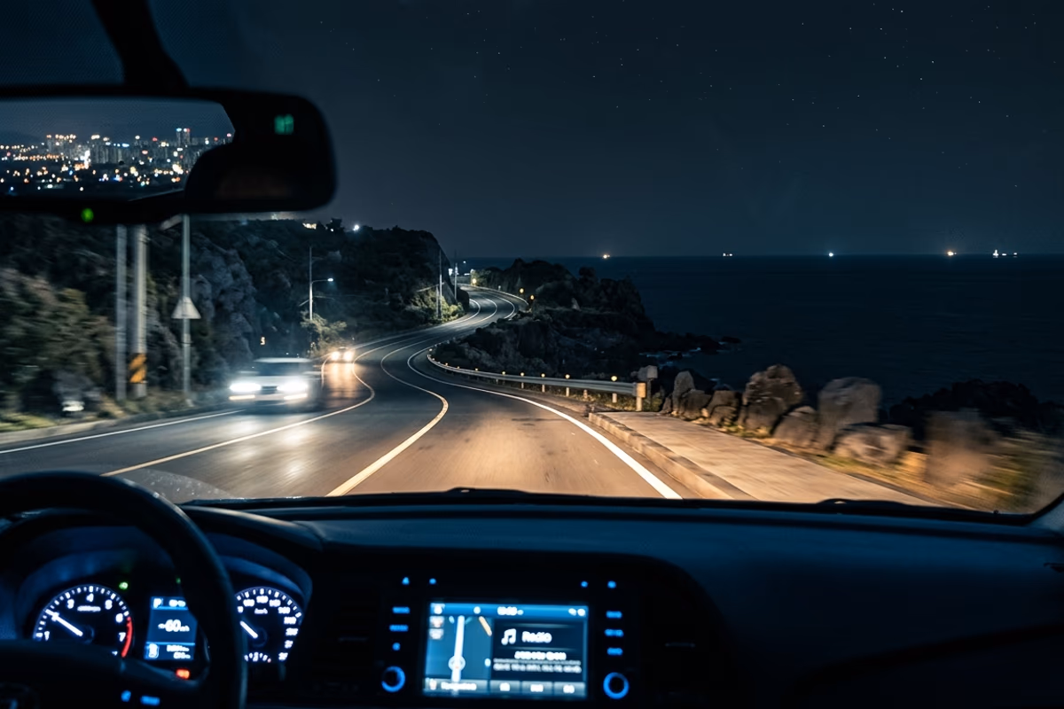 Coastal road night drive scene from Jeju City westbound toward Aewol