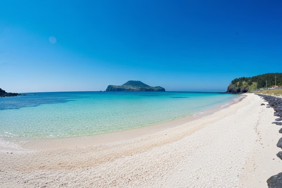 濟州挾才海水浴場翡翠色海面與白沙,遠方浮著飛揚島